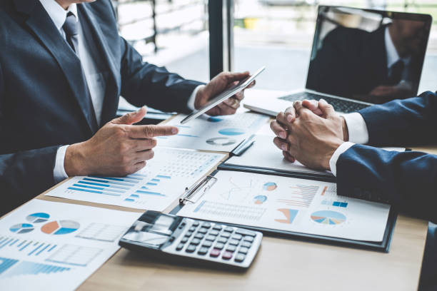 istock Two executive discussing company growth project success financial statistics, Partner meeting professional investor working start up project for both company with document, laptop and digital tablet 1173129291