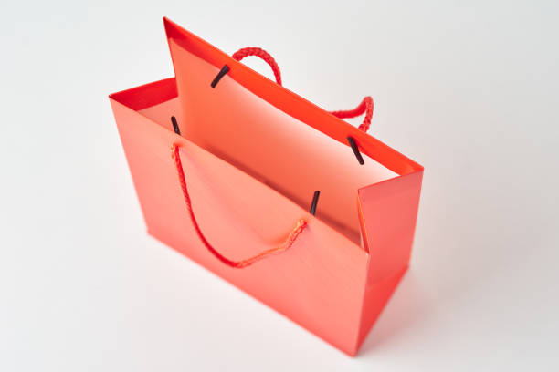 red sale shopping bags or kraft paper lined at the bottom of the frame on a white background
