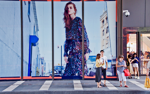 Fashion high street: Shoppers outside a clothing store displaying a huge ad board in Shenzhen Bay - China