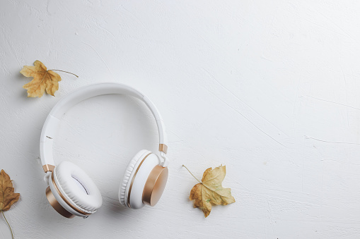 Top view of white headphones on white background with copy space. Flat lay. Music concept