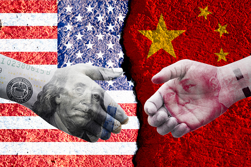 US dollar and China Yuan banknote print screen on handshake with both flags countries.It is symbol of economic tariffs trade war and tax barrier between United States of America and China.