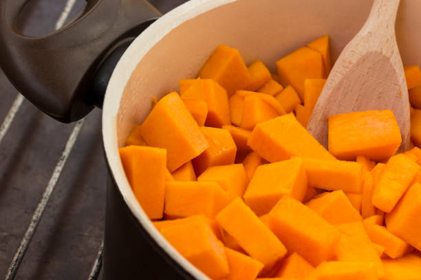 istock Sliced pumpkin close-up in a pan, wooden spoon 1173137982