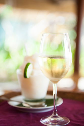 Close up photo of a male waiter serving champagne and pina colada to the customer, selective focus