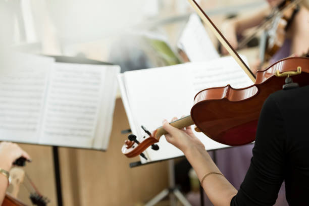 istock Woman playing violin with notes in front of her 1173140310