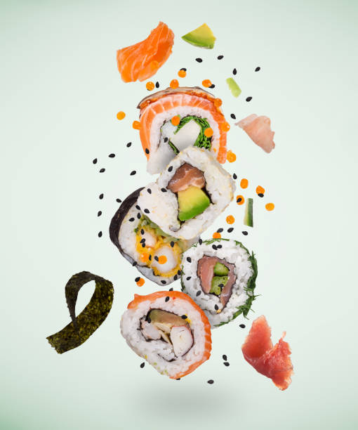 Pieces of delicious japanese sushi frozen in the air. Pieces of delicious japanese sushi frozen in the air on pastel color background. fusion food stock pictures, royalty-free photos & images