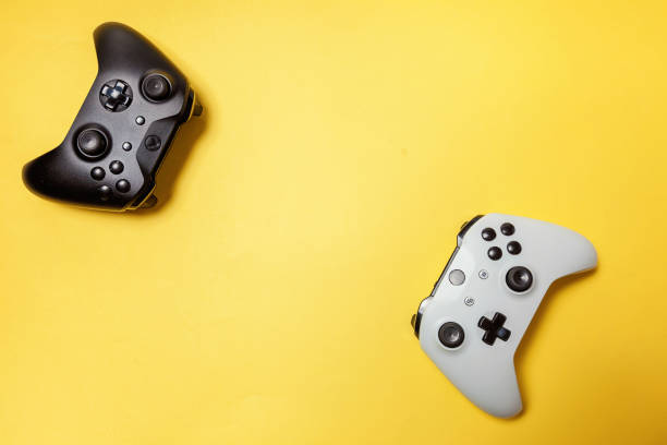 istock White and black two joystick on yellow background. Computer gaming competition videogame control confrontation concept 1173150819