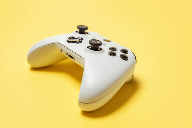 istock White joystick on yellow background. Computer gaming competition videogame control confrontation concept 1173150990