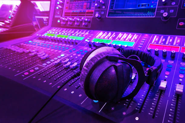 istock Professional audio studio sound mixer console board panel with recording , faders and adjusting knobs,TV equipment.  Blue and red tone and close-up image with flare light effect. 1173154826