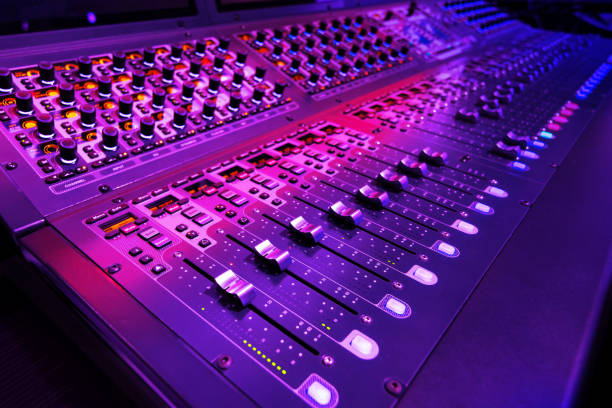 istock Professional audio studio sound mixer console board panel with recording , faders and adjusting knobs,TV equipment. Blue and red tone and close-up image with flare light effect. 1173155331
