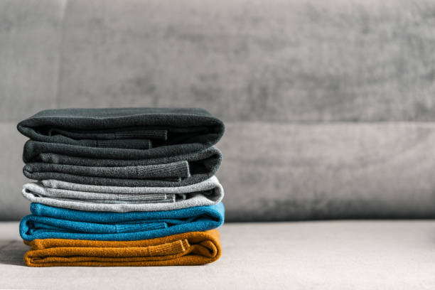 haufen pullover auf der grauen couch. herren textilbekleidung. - cashmere texture stock-fotos und bilder