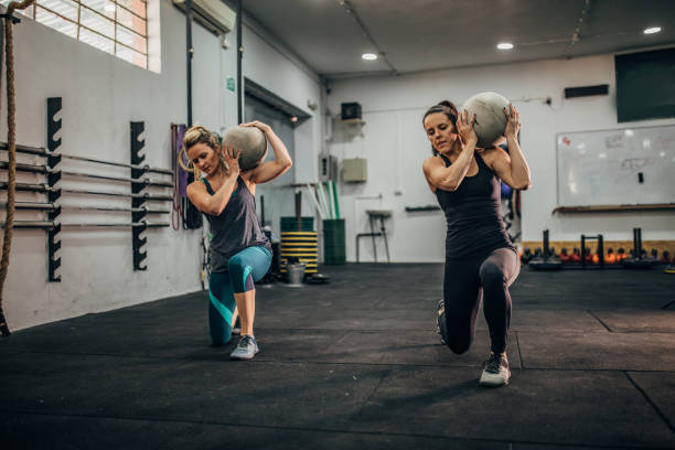 istock Women doing lunges with concrete ball 1173157575