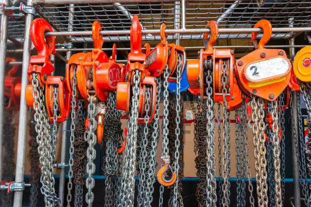 Multiple chain hoists hanging in a rack Multiple chain hoists hanging in a rack ready for use in a industrial environment, picture taken in the Netherlands hoisting photos stock pictures, royalty-free photos & images