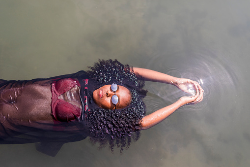 Beautiful young African American woman floating in a pool of water