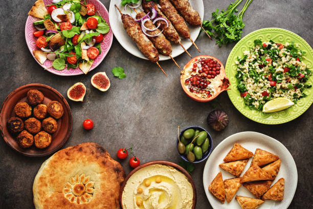 istock Assorted variety of Arabic and Middle Eastern food on a dark rustic background. Hummus,tabbouleh salad, salad Fattoush,pita,meat kebab,falafel,baklava. Set of Arabian dishes.Top view. 1173173538