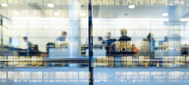 workers working late. tall building reflected - reflective glass imagens e fotografias de stock