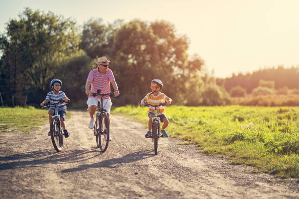 Grandfather riding bikes with his grandsons.
