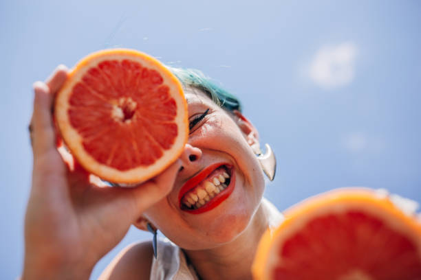 istock Pretty young woman holding grapefruit 1173175755