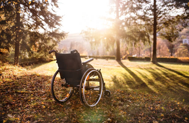 Empty wheelchair on a grass in park at sunset. An empty wheelchair on a grass in park at sunset. town of hope stock pictures, royalty-free photos & images