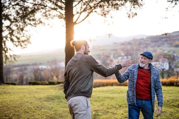 istock Senior father and his son on walk in nature, giving high five. 1173178554