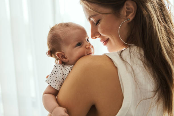 красивая мать с ребенком на плече - baby kissing mother lifestyles стоковые фото и изображения