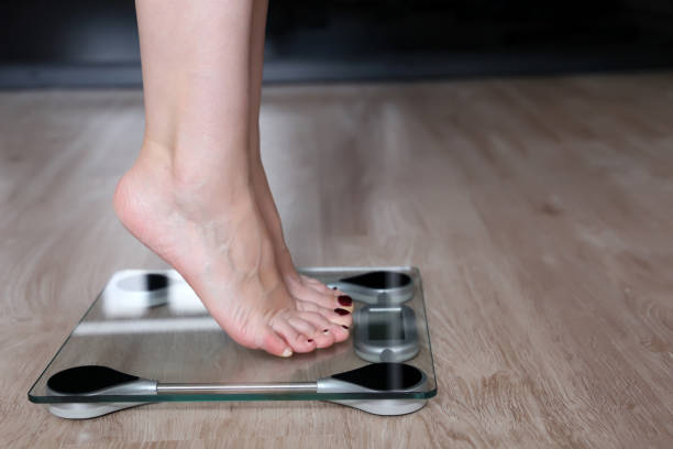 istock Slimming and diet, bare female feet on a scales 1173181611