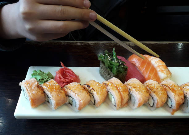 istock Taking philadelphia roll from set on white plate 1173182130