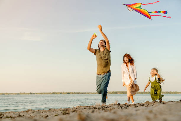 istock Family running through beach letting kite fly 1173182201