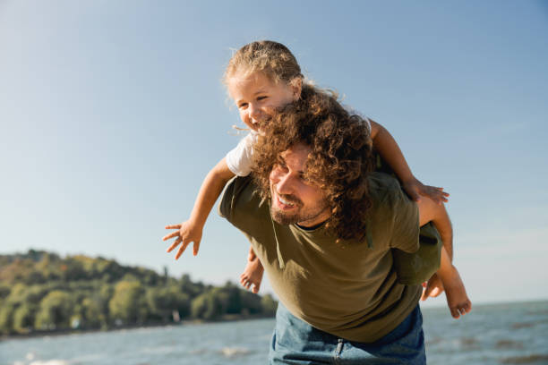 istock Happy father and daughter playing and having fun together on beach 1173182451