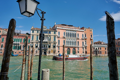 Venice, Italy - June 01, 2019: a commercial vessel sailing in Grand Canal among historical buildings.