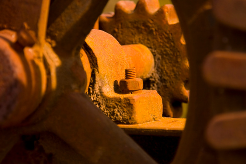 Close-up of a rusted machinery with gears and wheels.