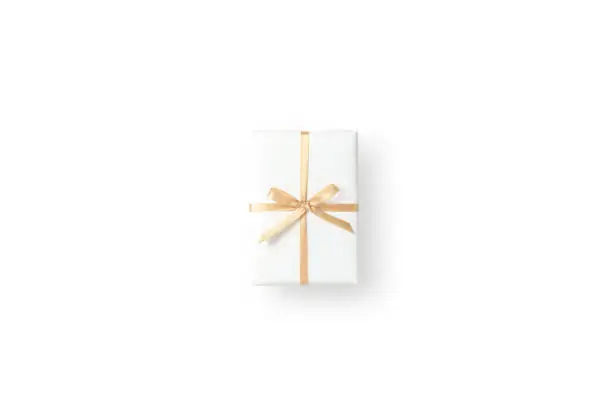 Photo of Top view of white gift box with gold ribbon on white isolated background