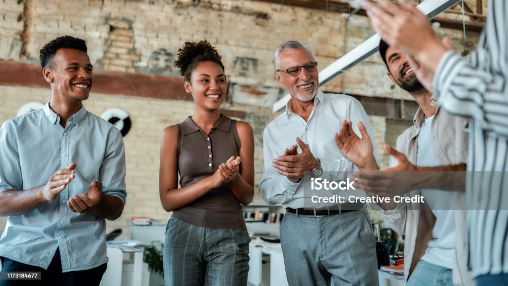Congratulations! Multicultural team clapping their hands and smiling while standing in the creative office Congratulations! Multicultural team clapping their hands and smiling while standing in the creative office. Celebrating success Encouragement Stock Photo