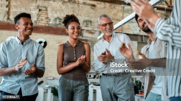 Congratulations Multicultural Team Clapping Their Hands And Smiling While Standing In The Creative Office Stock Photo - Download Image Now