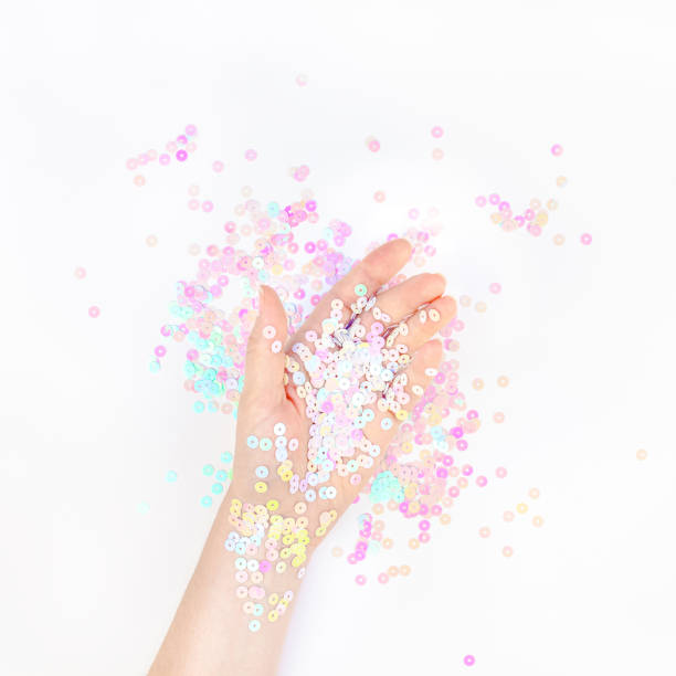 istock Pearl pastel confetti sparkles with woman hand 1173185915