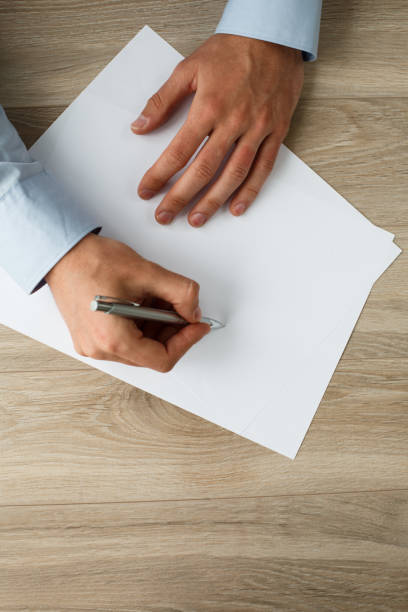 istock Hands of a businessman writing down on a blank paper 1173187746