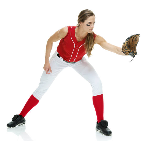 lunghezza intera / vista laterale / vista del profilo di 20-29 anni adulto bellissimi capelli castani / capelli lunghi caucasici femmina / giovane donna softball giocatore / atleta / lanciatore softball / lanciatore in piedi di fronte a sfondo bianco che s - softball adult catching beautiful foto e immagini stock