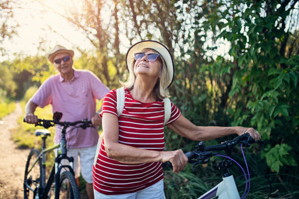 senior couple enjoying bicycle ride - old dirt road imagens e fotografias de stock