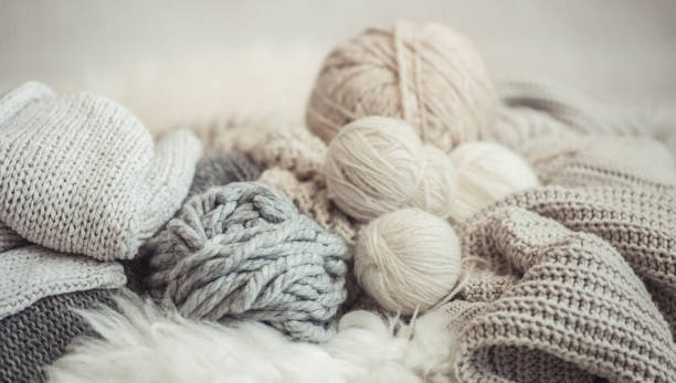 cozy background Wallpaper with the yarn for knitting. cozy background Wallpaper with a variety of threads for knitting. Close up. knitting needle photos stock pictures, royalty-free photos & images