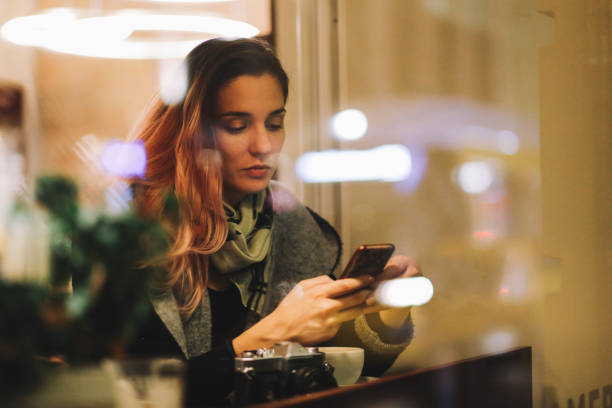 молодая женщина в берлинском кафе написала текстовые сообщения на смартфоне - berlin kreuzberg фотографии стоковые фото и изображения