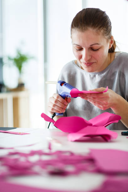 istock Smiling young woman using glue gun on her crafting project 1173190985