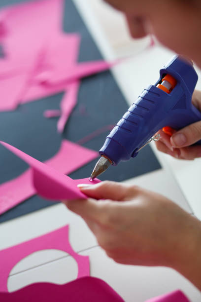 istock Woman using glue gun on her arts and crafts project 1173190987