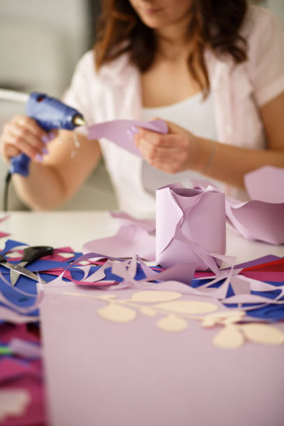 istock Gluing paper to make paper flowers on arts and crafts project 1173191009