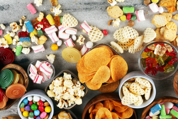 istock Salty snacks. Pretzels, chips, crackers and candy sweets on table 1173191016