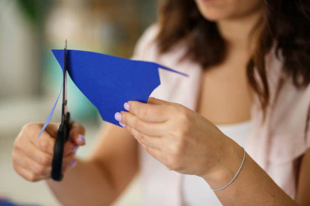 istock Cutting up stencils out of blue construction paper 1173191776