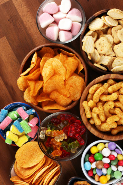 istock Salty snacks. Pretzels, chips, crackers and candy sweets on table 1173191958