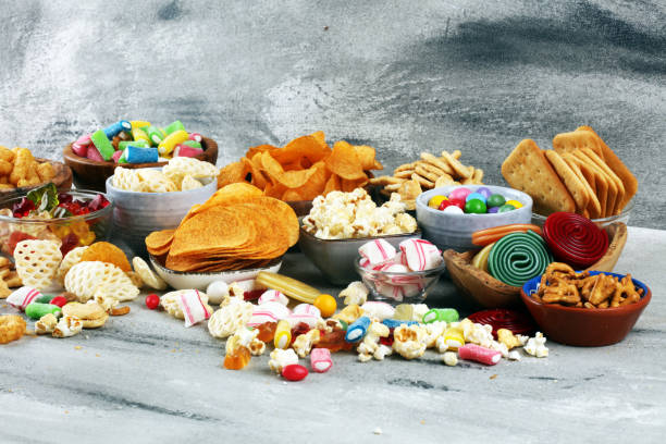 istock Salty snacks. Pretzels, chips, crackers and candy sweets on table 1173192132