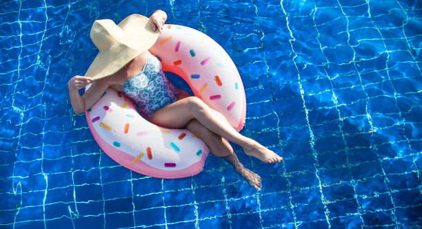 istock A woman in a hat relaxes on an inflatable circle in the pool. 1173192996