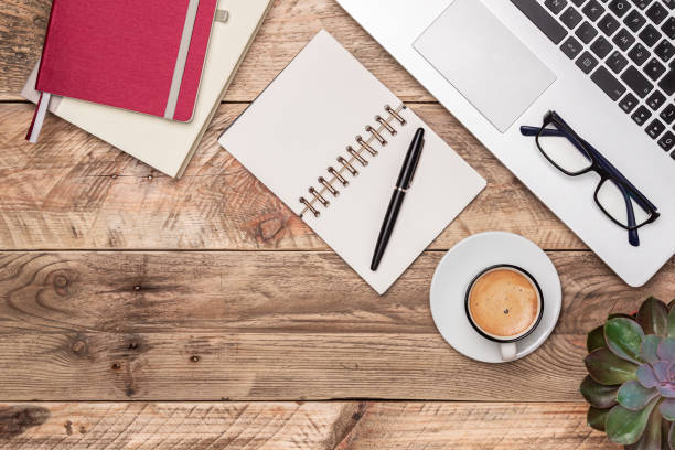 istock Rustic wooden desk top view with notebook, pen, laptop and coffee cup. Workspace with copy space. Office work, study or writing concepts. 1173194438