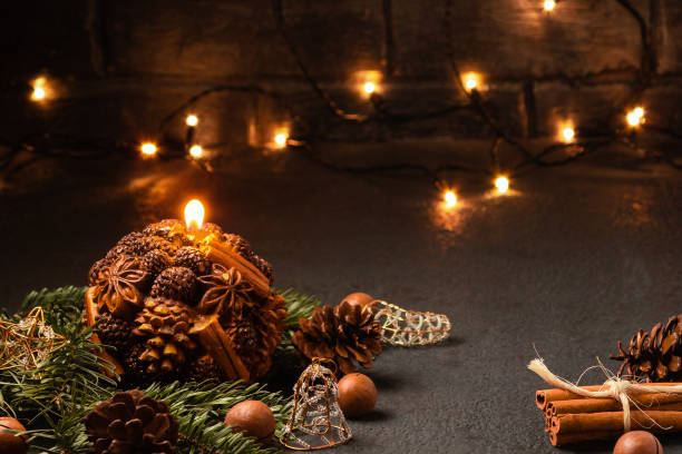 istock Christmas composition - decorative candle, Christmas tree branches and decorations on a dark background with blurry lights 1173195505