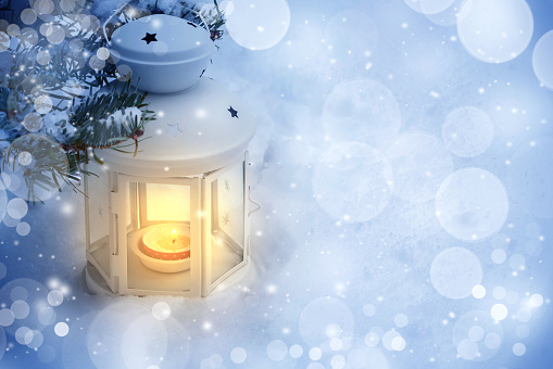 Christmas composition - a lantern with a burning candle under the Christmas tree, copy space, place for text.